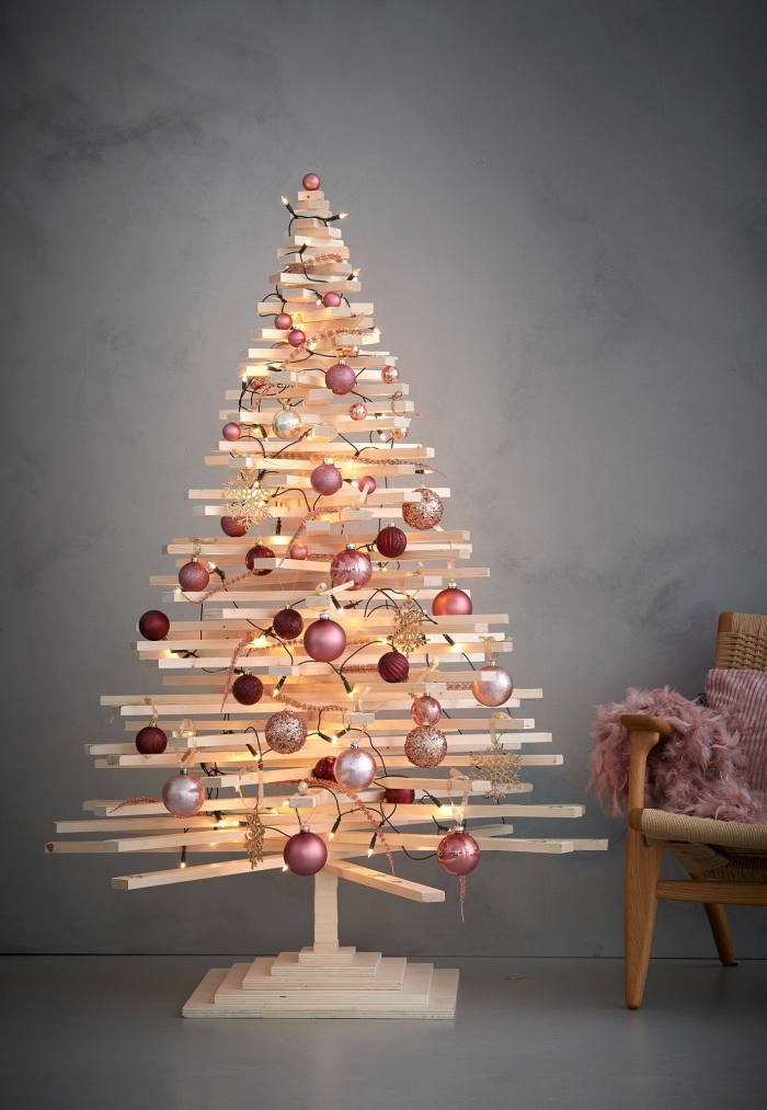 idée de deco de noel a faire soi meme, modèle de sapin minimaliste fabriqué avec goujons de bois et décorés avec boules en nuances de rose