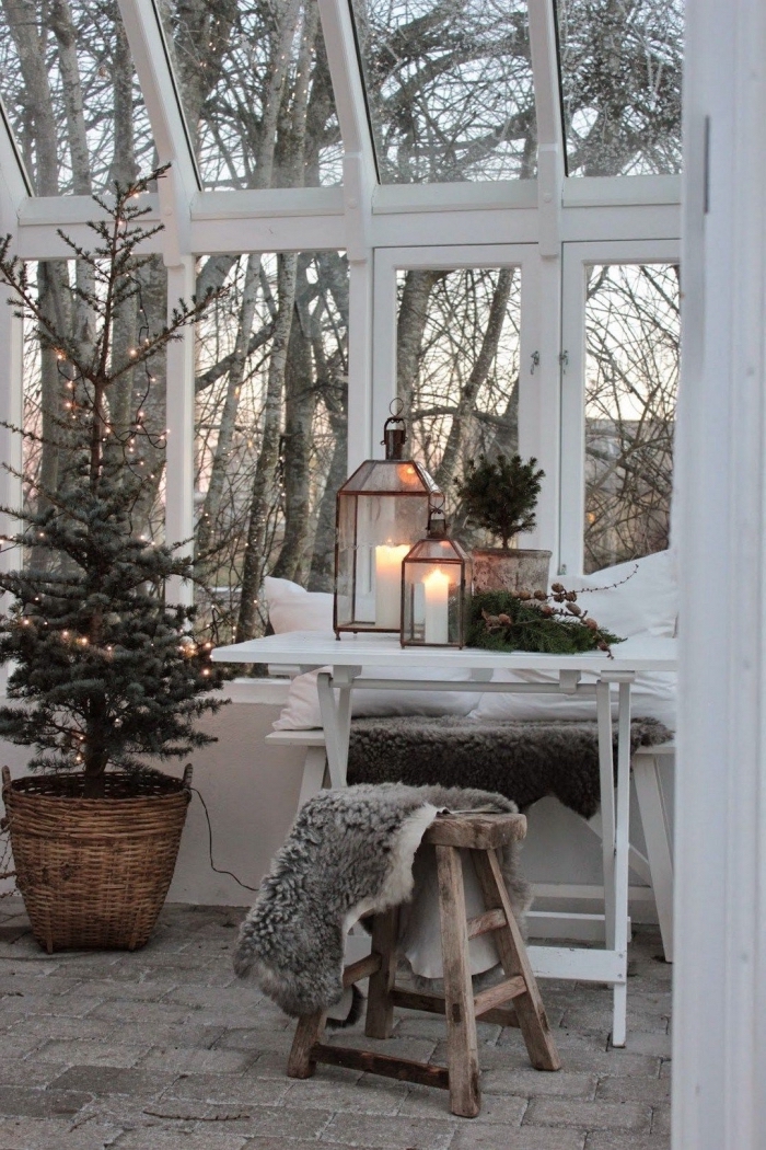 ambiance cocooning dans une pièce aux grandes fenêtres aménagée avec meubles en bois, idée deco noel nature avec arbre de Noël naturel