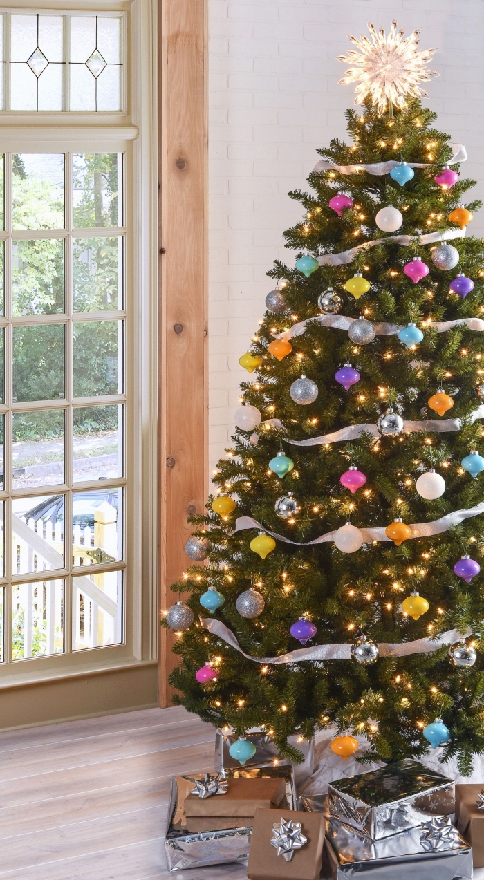 quel thème de décoration pour un sapin de Noël original, image sapin de noel naturel décoré avec ruban argent et boules différentes couleurs