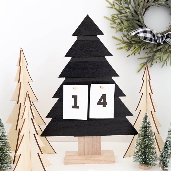 modèle de calendrier de l'avent DIY à réaliser avec sapin de noel en bois repeint en noir mat et des morceaux de papier numérotés