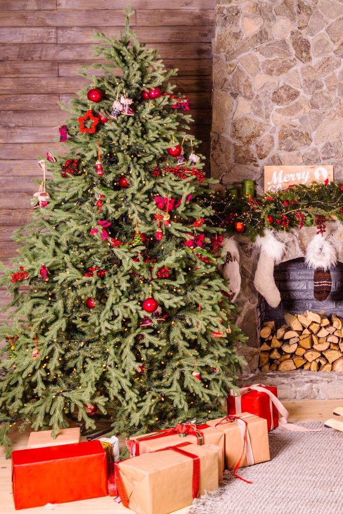 idee deco sapin de noel traditionnelle avec ornements et papillons rouges, ambiance cozy dans un salon décoré pour Noël