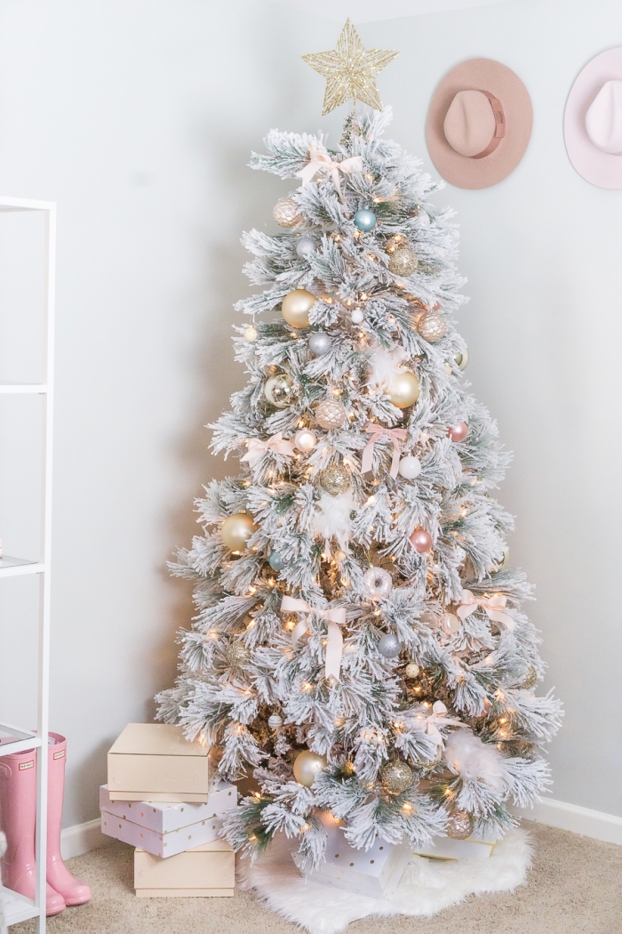modèle de gros sapin artificiel aux branches blanches décoré avec boules dorées et ruban de couleur rose pâle