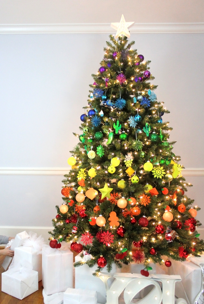 modèle arbre de Noël décoré à effet arc en ciel, image sapin de noel naturel décoré dans un salon aux murs blancs avec plancher bois foncé