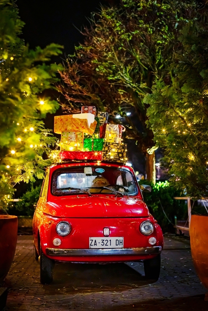 photo joyeux noel pour écran de verrouillage, idée photo de nuit avec lumières festives et mini voiture avec cadeaux de Noel, image de pere noel