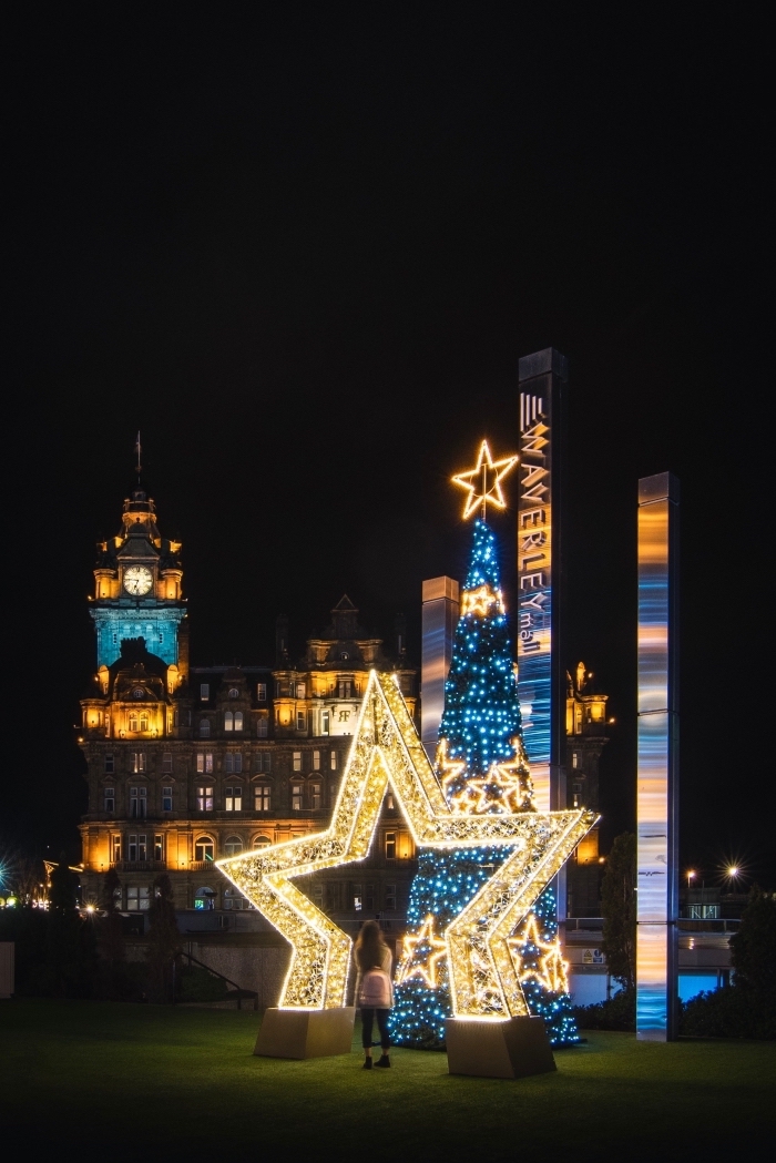 image de pere noel célébration pour fond d'écran portable, photo de nuit avec géant sapin et étoile lumineux