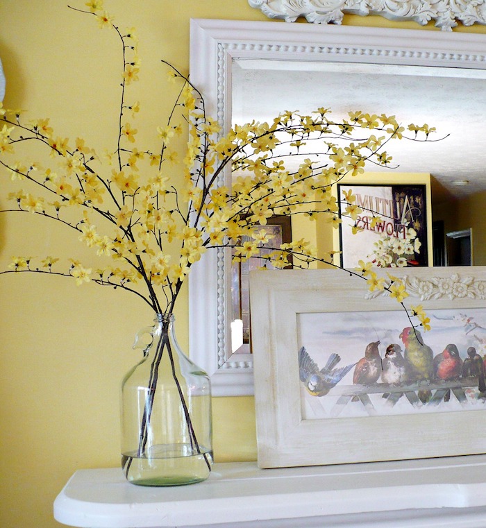 Branche fleurie aux jaunes fleurs, vase dame jeanne, composition florale à faire soi meme, vase de bouteille dame-jeanne, mur jaune