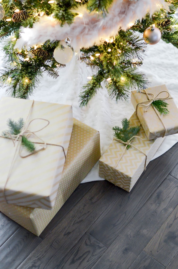 Parfum à offrir en cadeau pour femme ou pour homme, cadeaux joliment emballés sous l'arbre de noël décoré
