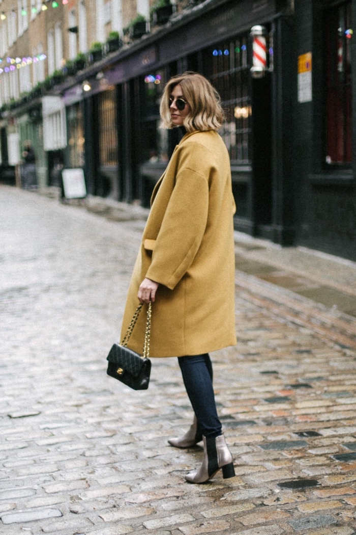 modèle de manteau femme hiver 2020 de couleur jaune à taille oversize avec poche, look femme chic en jeans et chaussures hautes