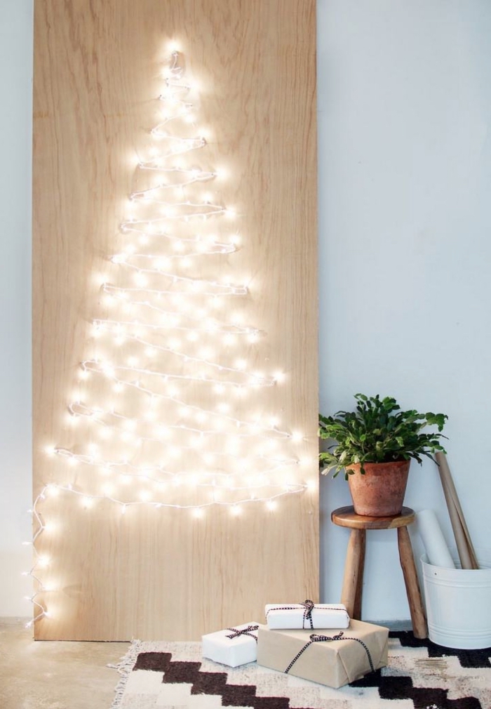 modèle de panneau lumineux pour Noël fait main avec planche de bois troués et guirlande lumineuse en forme de sapin