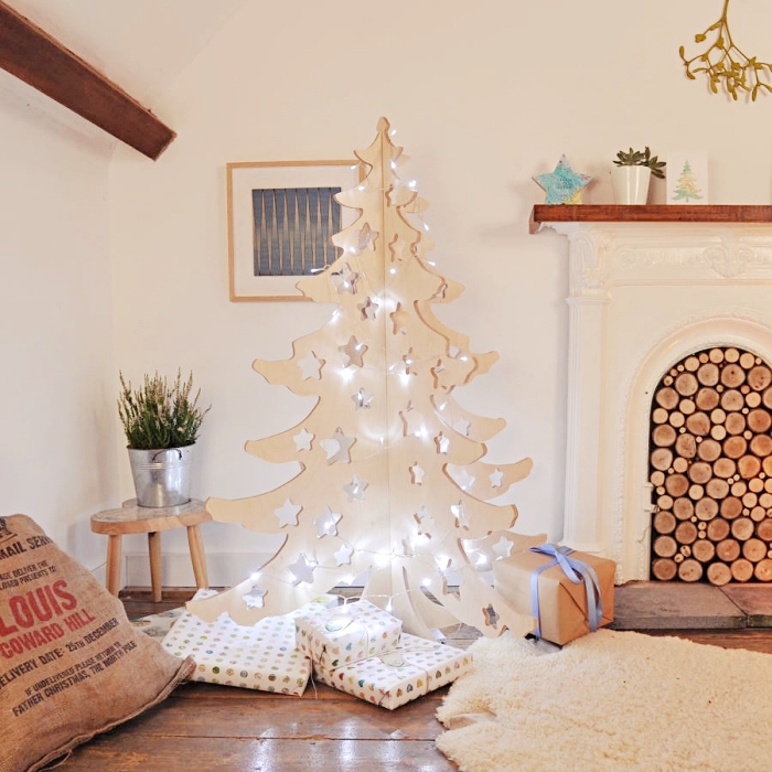 diy decoration noel a faire soi meme, modèle d'arbre de Noël fait en bois clair et décoré avec guirlande lumineuse