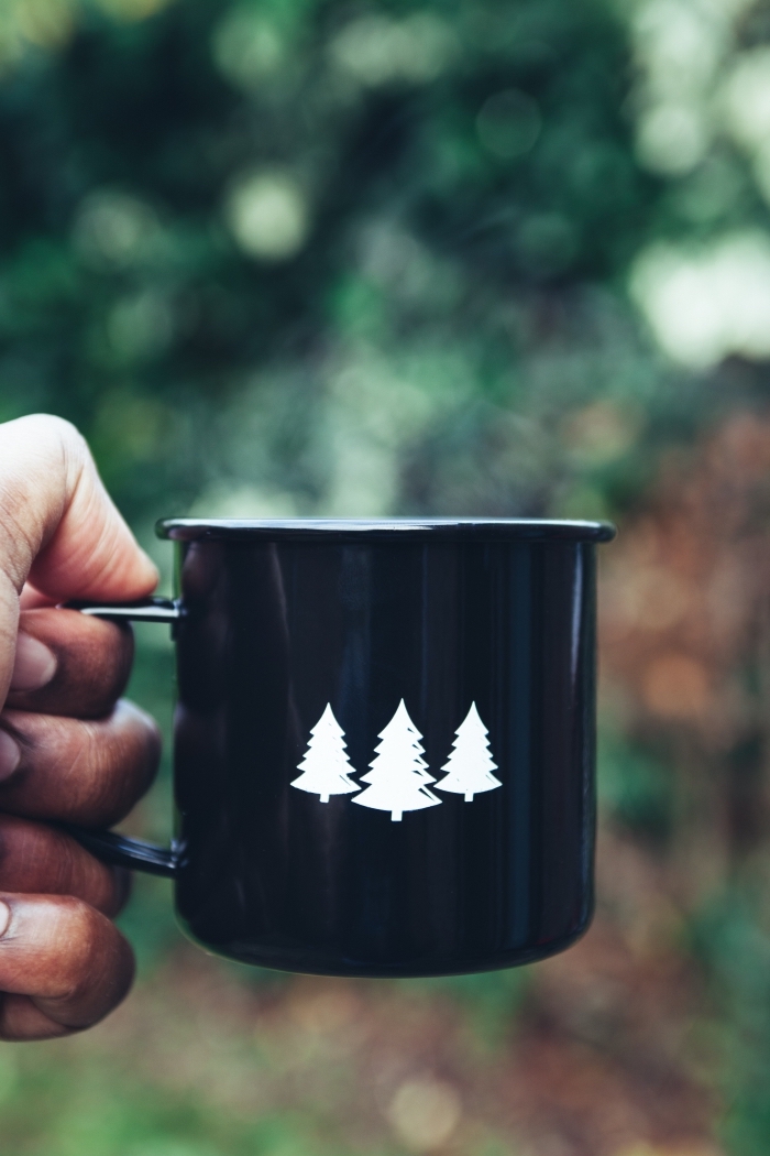wallpaper iphone Noel de style minimaliste, photo verrouillage d'écran sur le thème camping Noël avec un mug noir à motifs mini sapins blancs