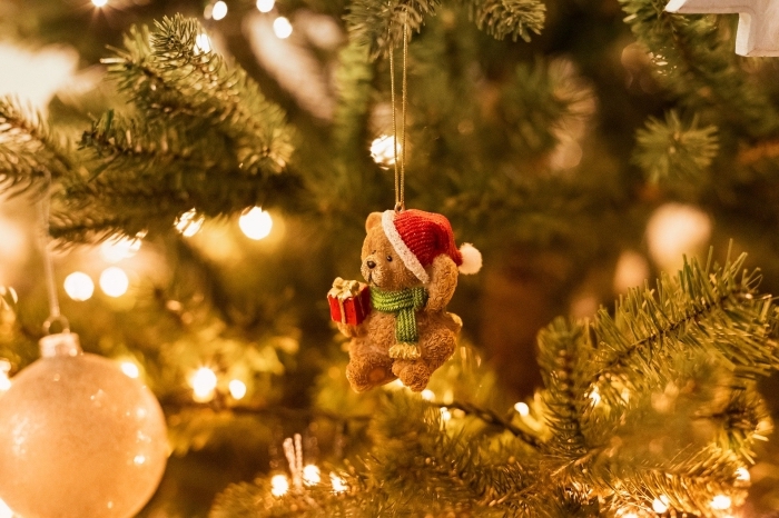 photo sapin de noel naturel décoré avec guirlande lumineuse et figurine ours de Noel, idée fond d'écran ordinateur pour Noel
