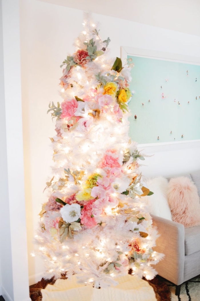 modèle de sapin de noel artificiel aux branches blanches décoré avec guirlande lumineuse et florale, idée comment decorer un sapin