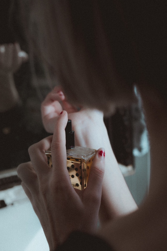 Femme avec bouteille de parfum dans la main, idée quel parfum choisir pour offrir comme cadeau 
