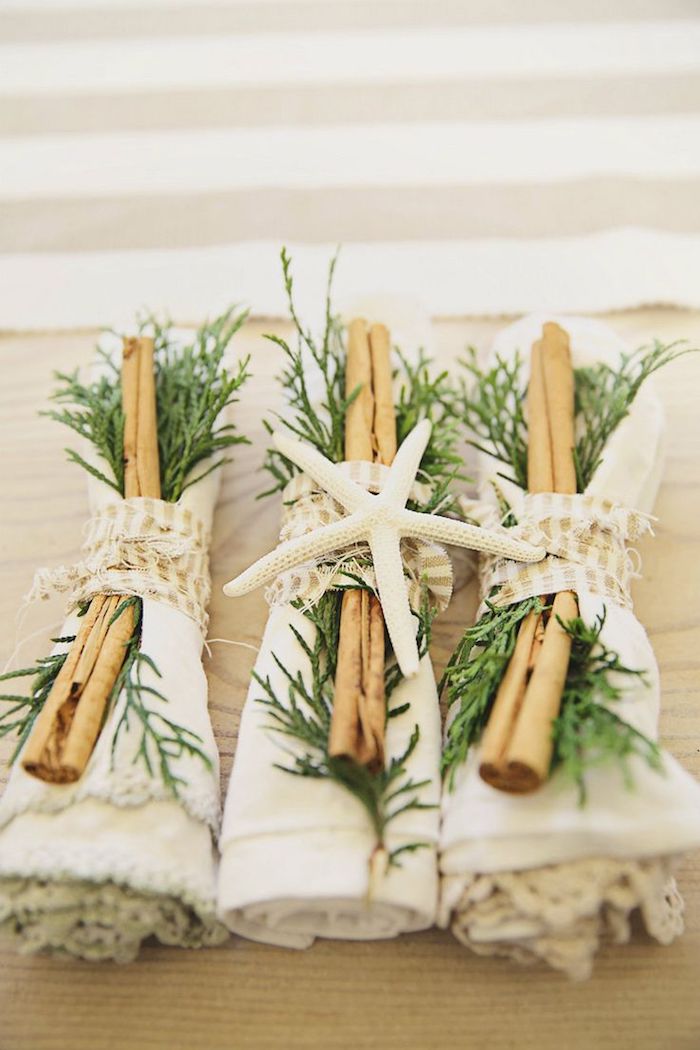 rond de serviette étoile de mer, branches de pin et batons de cannelle autour d une serviette à bordure de dentelle, décoration de table idées