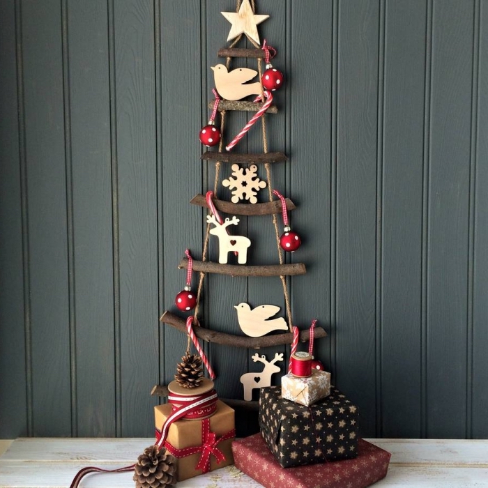 diy sapin suspendu en mini branches de bois foncé avec étoile en bois au sommet et décoration minimaliste avec figurines bois