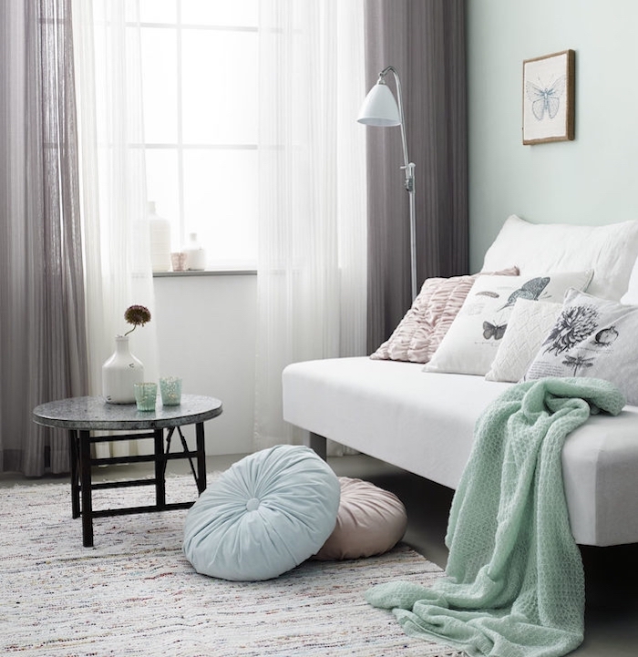 Canapé blanc avec couverture gris menthe, rideaux gris et blanc, dessin de papillon en crayon encadré, deco chambre moderne, idée déco chambre adulte