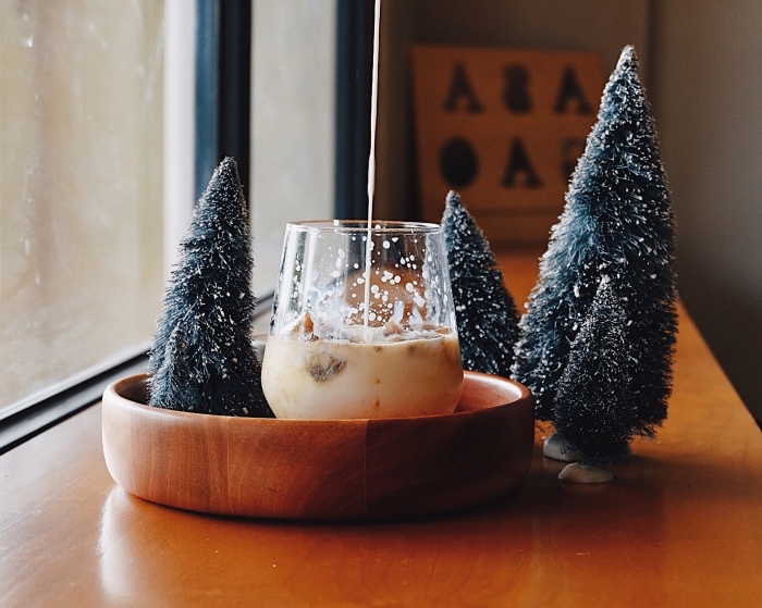 cozy ambiance de Noël avec une boisson au lait et figurines de mini arbres de Noël artificiels, fond d'écran PC pour Noël