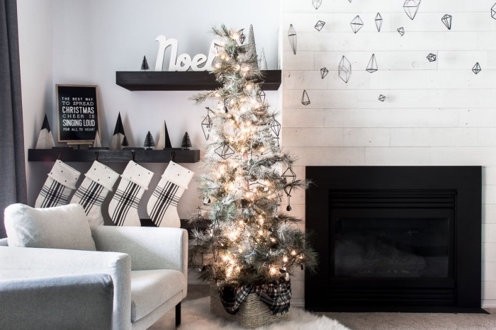 comment décorer un salon scandinave pour Noël, image sapin de noel artificiel décoré avec guirlande lumineuse et figurine en fil de fer