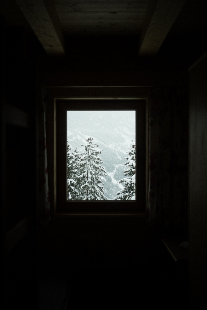 idée belle image de noel pour fond d'écran iphone, photo de paysage enneigé avec sapins devant une fenêtre de chambre sous combles