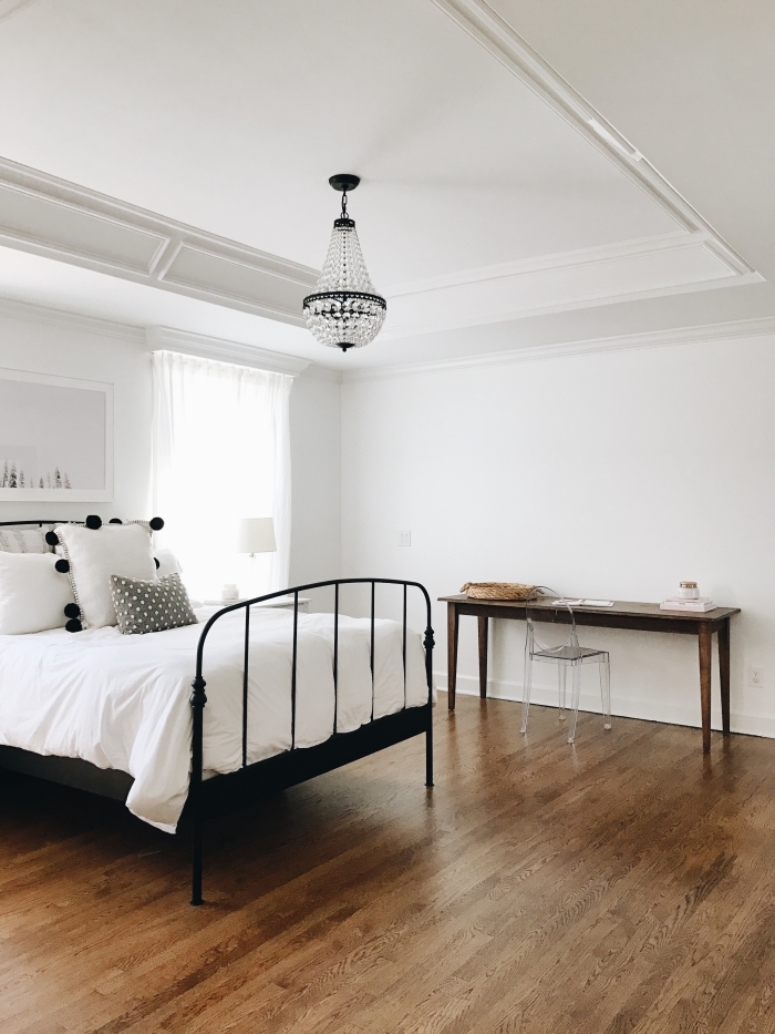 design minimaliste dans une chambre adulte aux murs blancs et plancher en bois foncé avec diy bureau bois brut