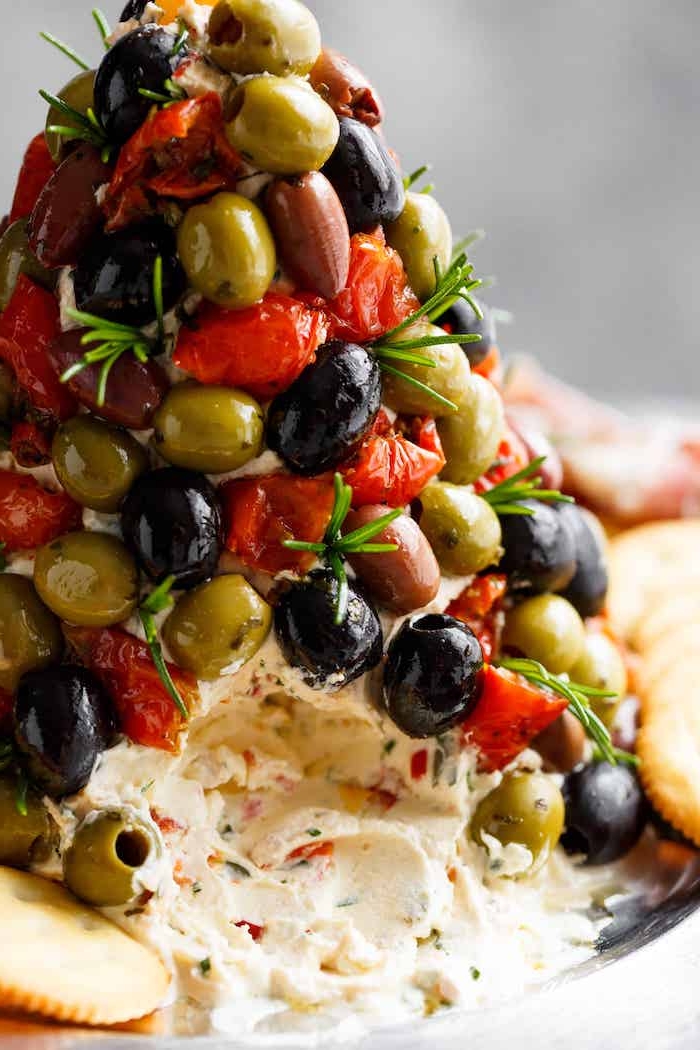 arbre de noel de fromage aux herbes fraiches et decoration d olives vertes et noires avec des poivrons rouges
