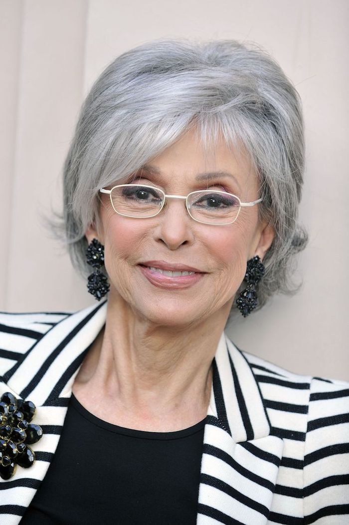 coupe de cheveux court femme 60 ans avec lunettes et frange asymetrique et volume sur le dessus de la tete, cheveux gris poivre et sel