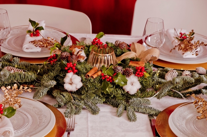 exemple comment décorer une table de Noël avec composition diy, arrangement en branches de sapin décorées de ruban doré