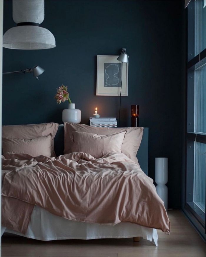 idée de deco chambre adulte aux murs bleu foncé avec objets en rose poudré et blanc, aménagement petite pièce aux murs sombres