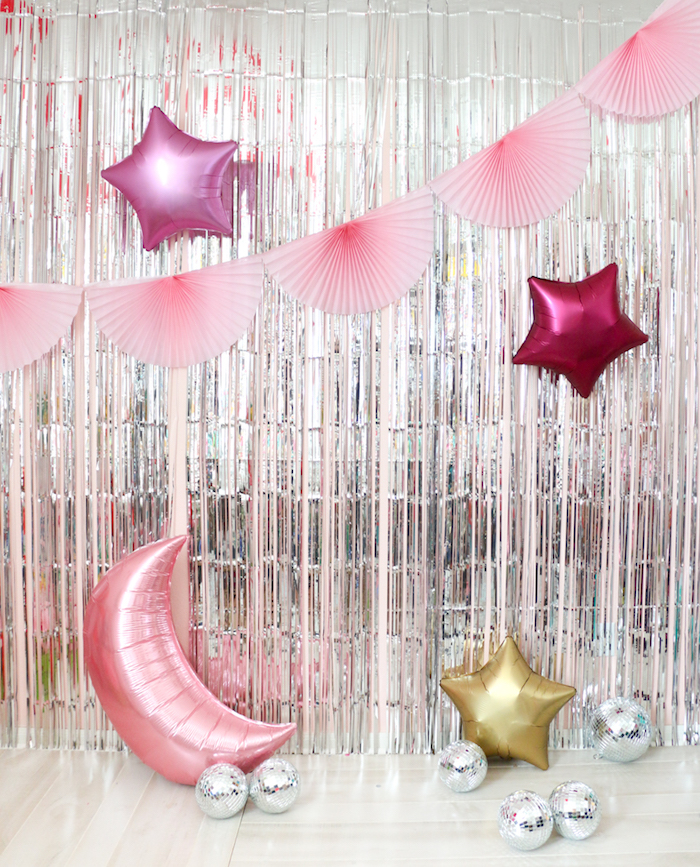 rideau à franges argentées pour décorer un mur avec guirlande d éventails rose, ballons en forme de lune et étoile, balles à facettes