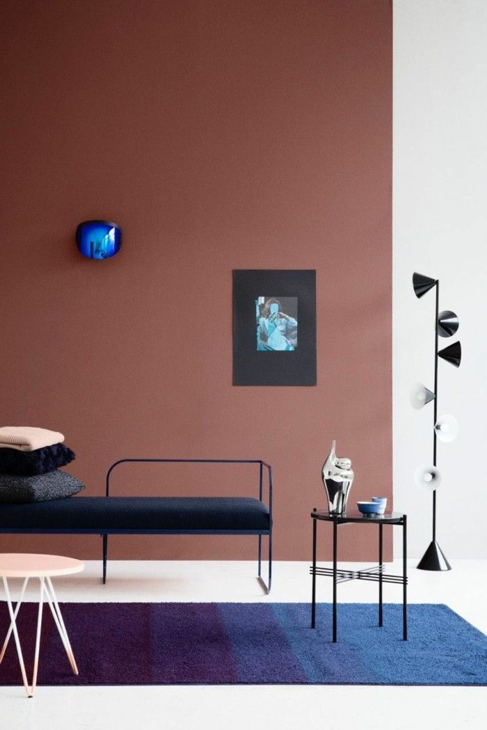 Tapis bleu sombre sur sol blanc et mur en deux couleurs brune et blanc, lampe design, comment disposer les couleurs de peinture dans une pièce moderne