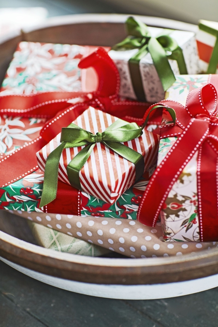 décorer la table de Noël avec objets fait main, centre de table dans une assiette bois remplie de cadeaux emballés diy
