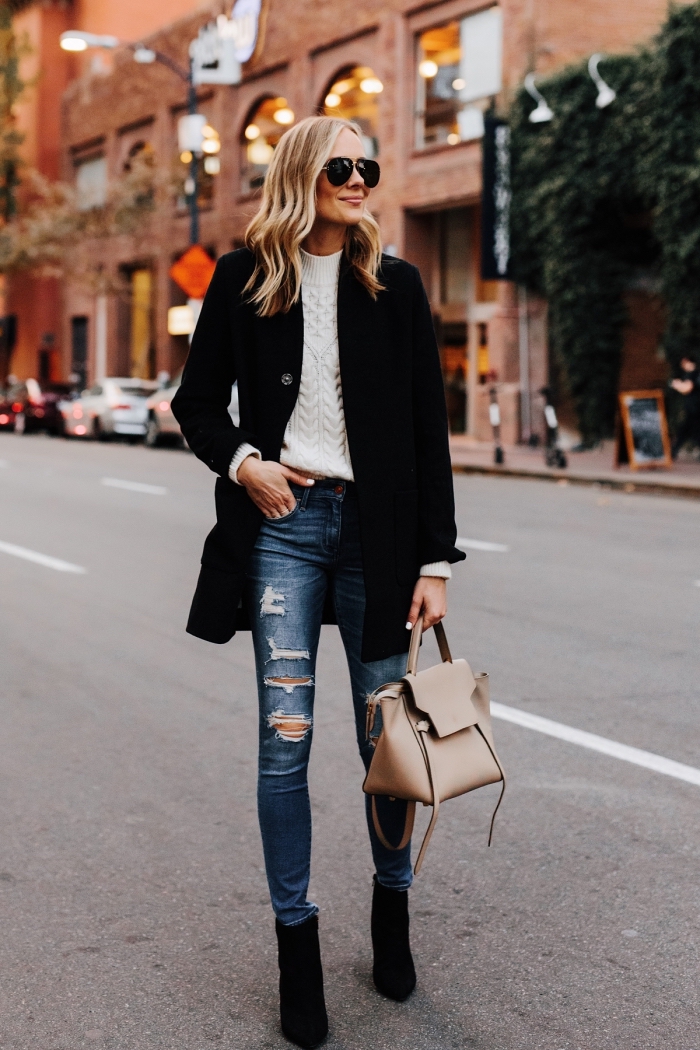 style vestimentaire femme au travail en jeans déchirés combinés avec sweat femme marque de couleur blanche et manteau noir