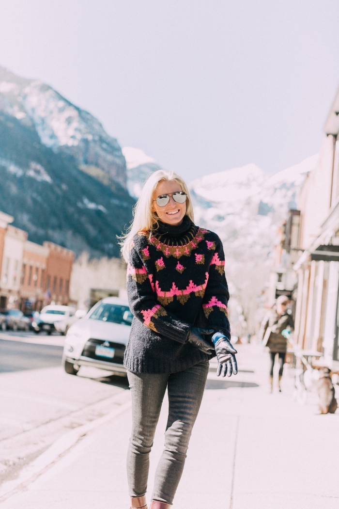 modèle de pull de marque femme de couleur noire à imprimés fair isle combiné avec jeans foncés et bottes marron