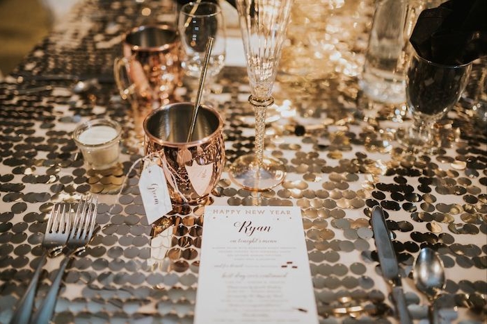 deco table nouvel an à détails de table couleur or metallique, bougies decoratives et verres rose gold, couverts en argent