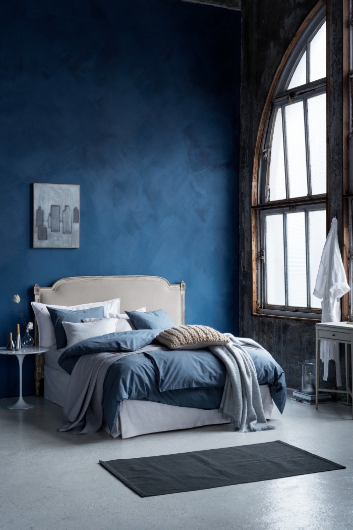 peinture de couleur bleu marine dans une pièce à haut plafond avec sol gris et meubles en blanc, idée déco chambre aux murs sombres