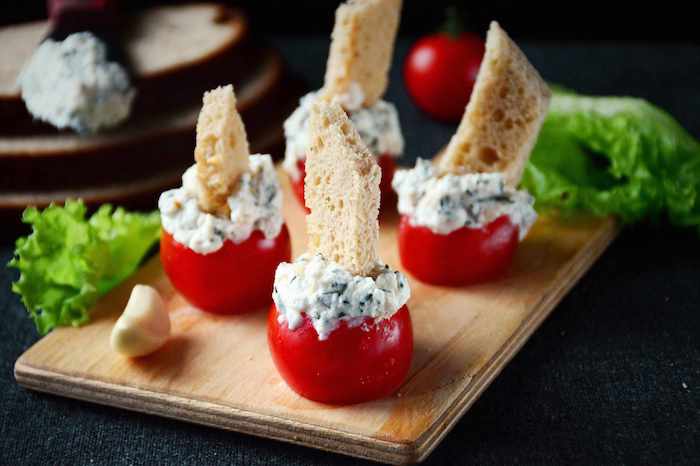 tomate cerise farcie de fromage à la crème aux herbes avec un bout de pain planté, apéritif dinatoire simple