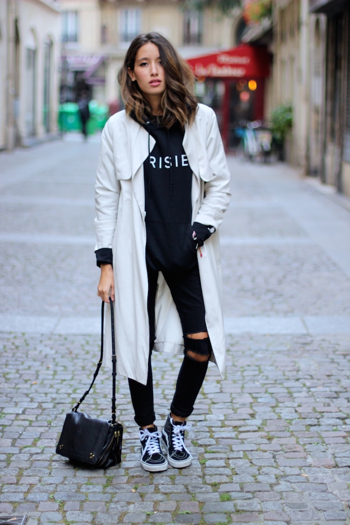 Manteau blanc long, jean noir déchiré, sac débardeur noir cuire, style streetwear femme, tenue swag hip hop street style