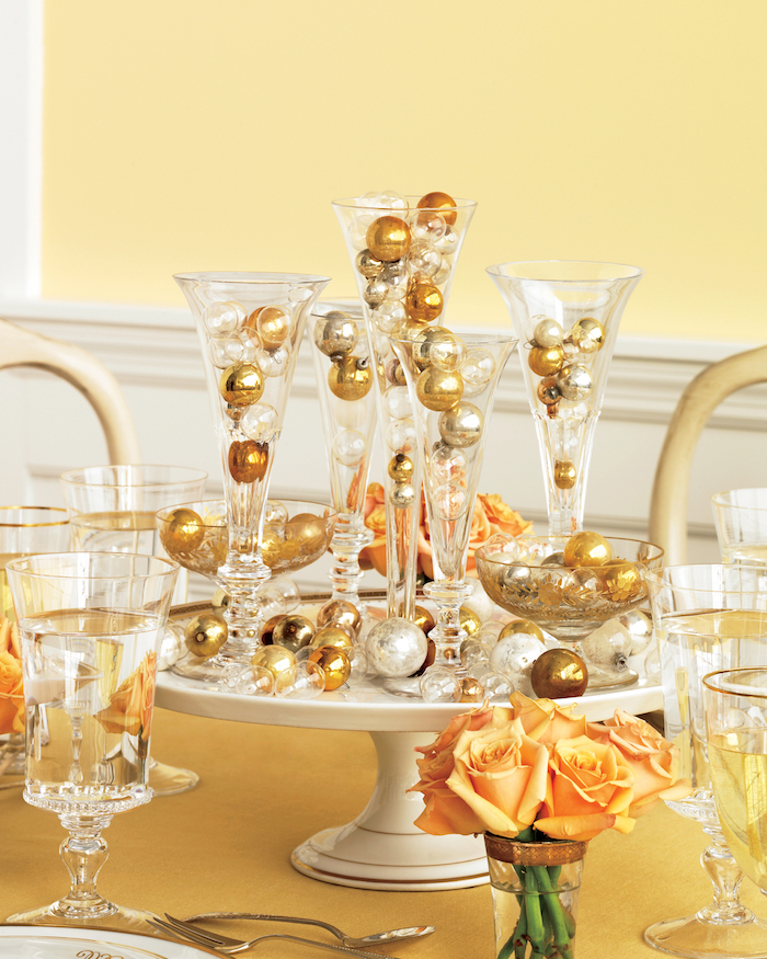 centre de table plateau blanc avec vases transparentes décorés de boules d or et d argent, mini bouquet de fleurs orange, deco centre de table original
