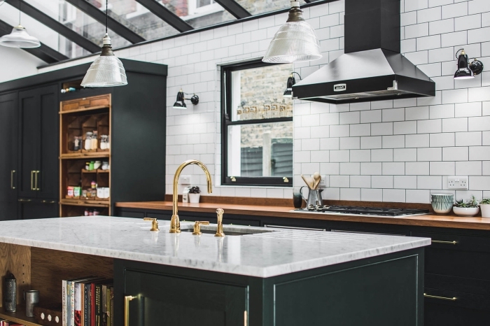 modèle de cuisine contemporaine aux murs en carrelage effet briques blanches aménagée avec meubles en vert de gris