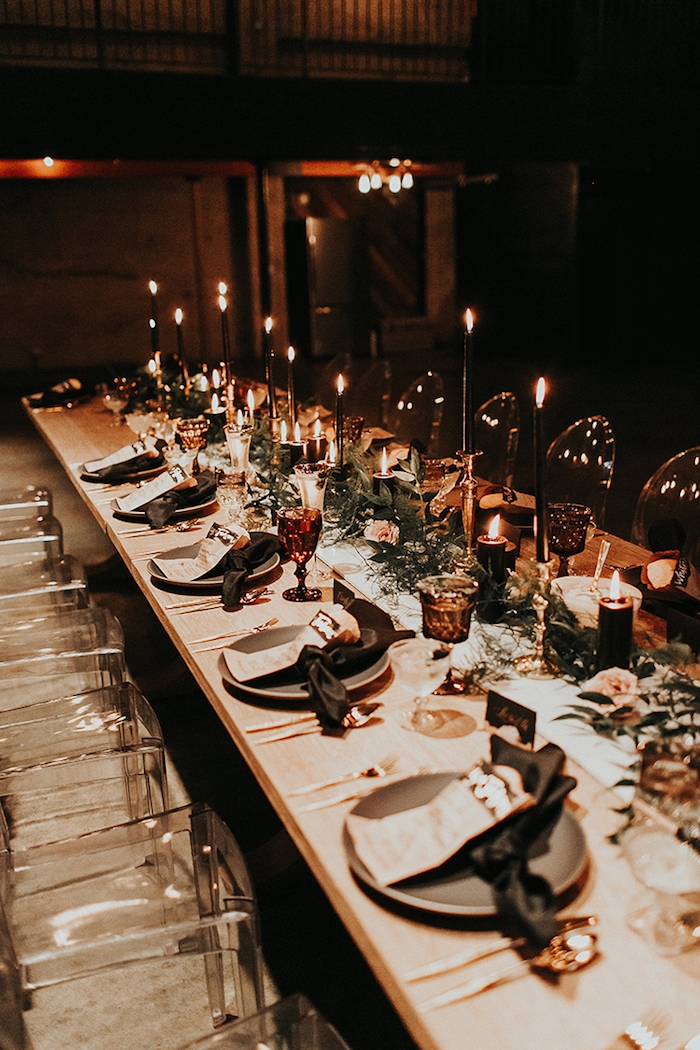 theme de mariage romantique, lumière tamisée provenant de bougies décoratives originales, centre de feuillages et fleurs chaises en verre