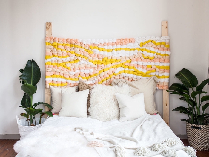 modèle de tete de lit a faire soi meme avec deux planches à bois et morceaux de tissu tressés en couleurs rose et jaune