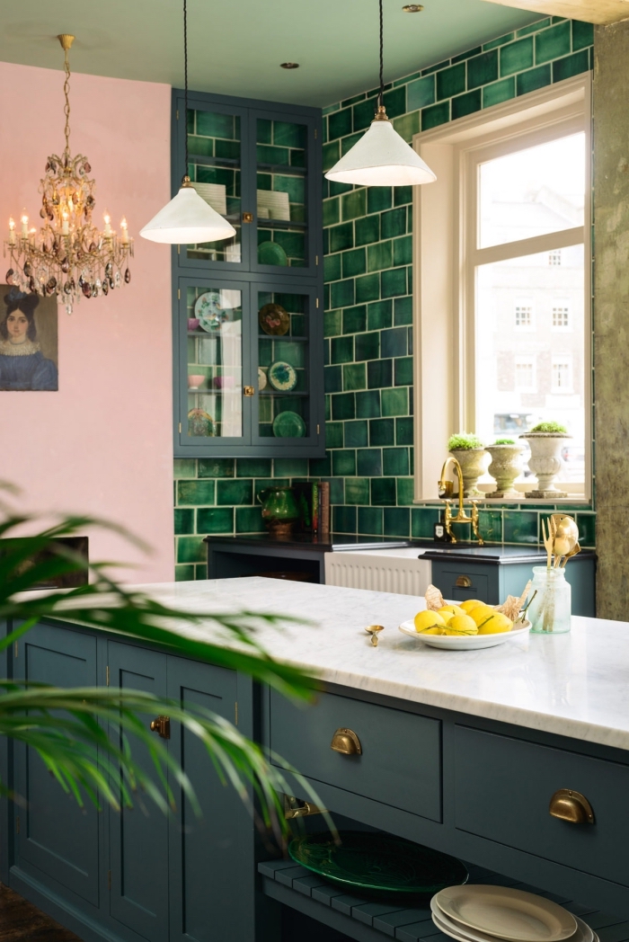comment aménager une cuisine moderne de style tropical avec pan de mur rose et meuble de couleur vert de gris