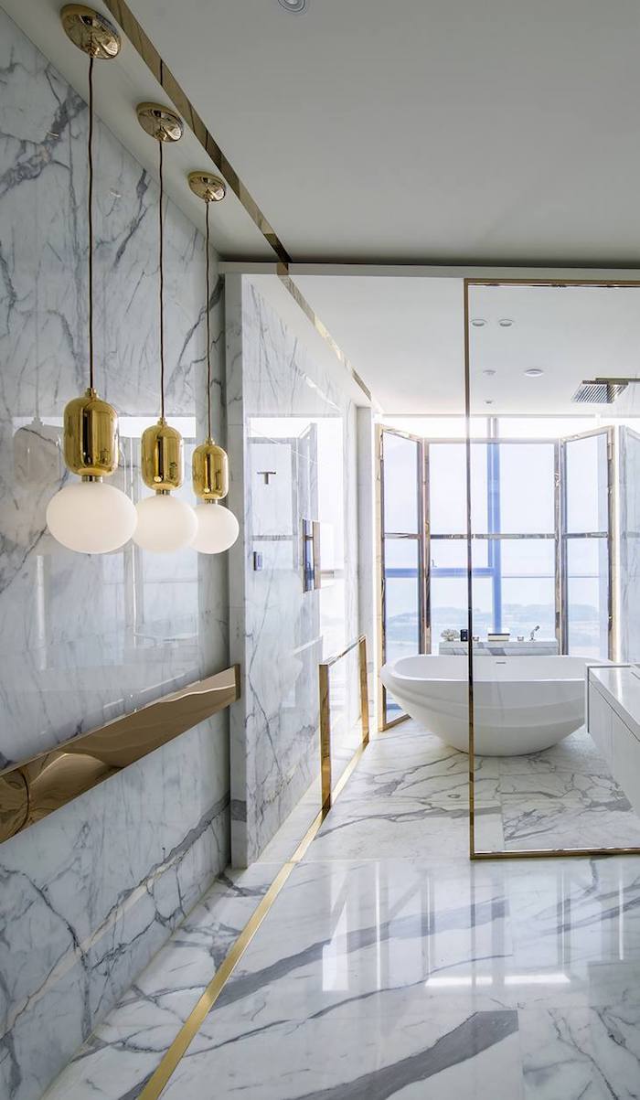  Salle de bain marbre blanc avec gris, chouette idée pour la salle d'eau accessoirisé en or, baignoire avec vue de la ville