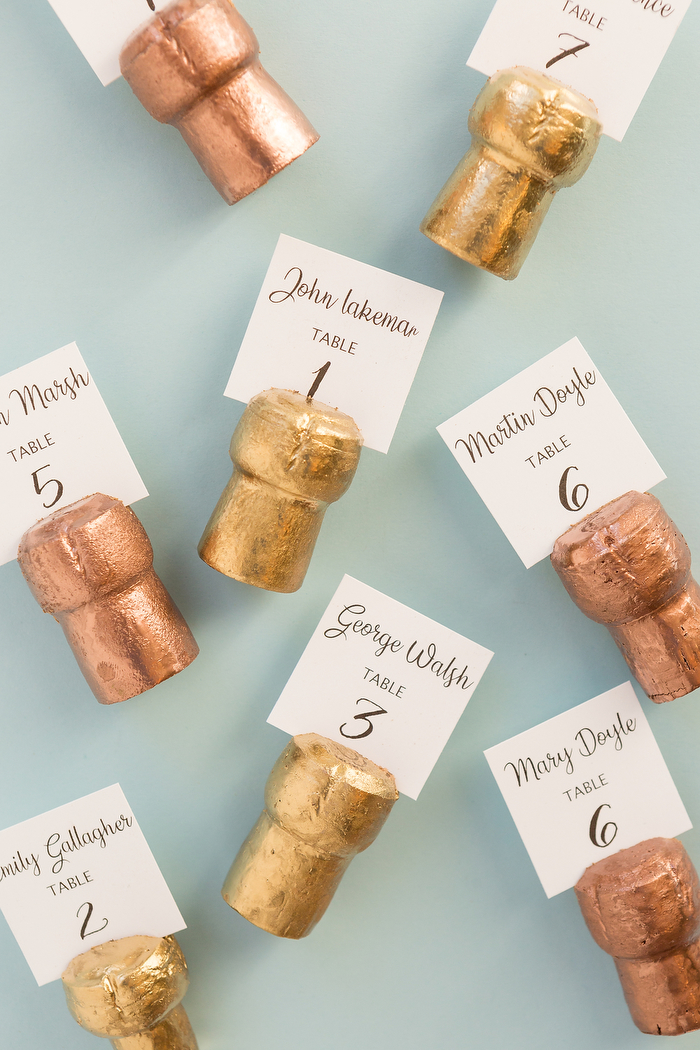 marque place mariage originale, idee diy pour recycler des bouchons de liège colorés de peinture or avec étiquette numéro de table