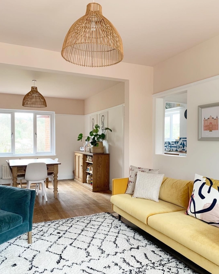idée de decoration salon 2020 aux murs rose pastel et sol en bois foncé aménagé avec meubles en tissu coloré