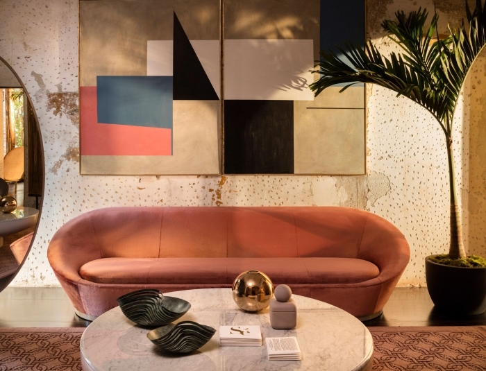 design salon moderne aux murs en papier peint à effet et sol en carrelage beige aménagé avec un canapé tendance 2020 en velours terracotta