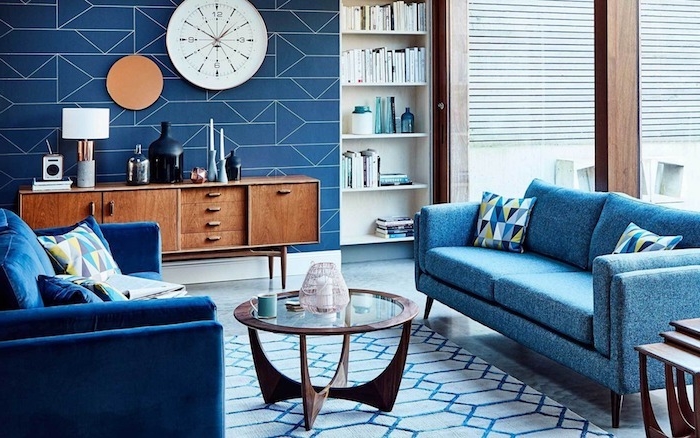 canapés couleur bleue dans un salon bleu et blanc, table basse bois et verre, horloge blanche, meuble tv de bois, tapis blanc et bleu