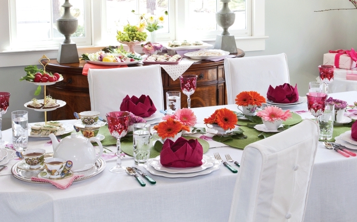 exemple comment décorer une table festive en blanc et rouge, idée de pliage de serviette en papier sous forme de lotus