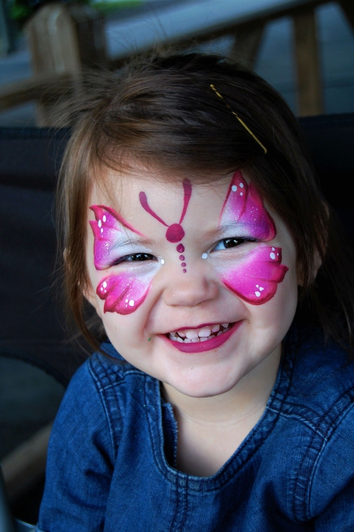 modèle de maquillage papillon facile à faire avec peinture facile de couleurs rose fuchsia et blanche sur visage fille